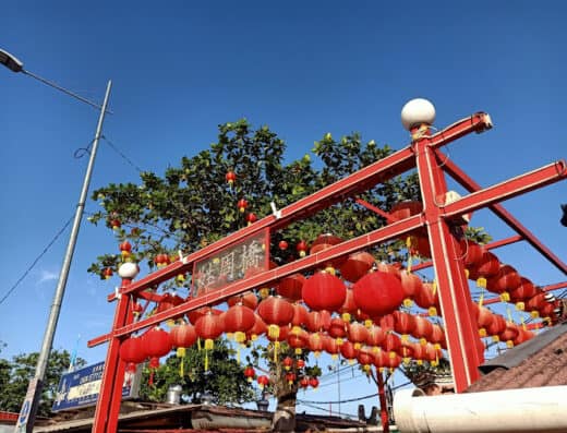 Red Chinese lanterns hanging on a gate for Chinese New Year celebration or festival, vibrant red decorations, traditional cultural ornament, festive atmosphere in an outdoor setting.