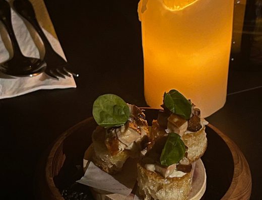 A flavorful sushi dish topped with herbs, served on a wooden platter in a cozy, dimly lit setting. Perfect for sushi lovers seeking authentic Japanese cuisine.