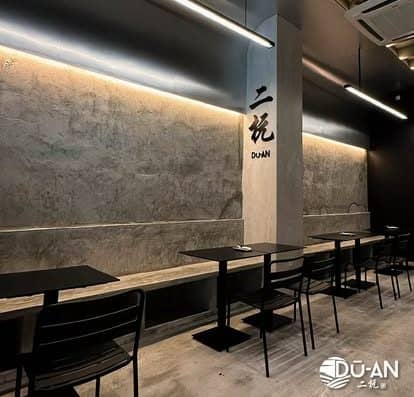 Stylish cafe interior featuring sleek black tables and chairs, minimalist design elements, and soft lighting. Perfect for a relaxing dining experience in a contemporary setting.