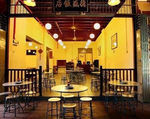 A cozy Asian restaurant with warm yellow walls, modern lighting, and traditional decor, offering an inviting ambiance for diners seeking authentic Asian cuisine.