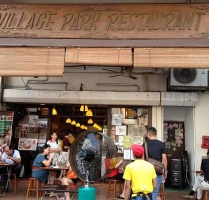 Vibrant outdoor dining at Village Park Restaurant with guests enjoying delicious local dishes in a lively atmosphere. Perfect for authentic Vietnamese cuisine experiences in a cozy setting.